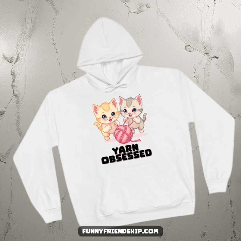 Funny playful kittens chasing a bouncing ball of yarn together on a warm hoodie, a super cute and cozy sweatshirt